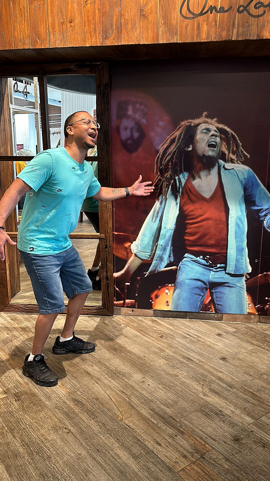 Herman laughing next to a Bob Marley mural
